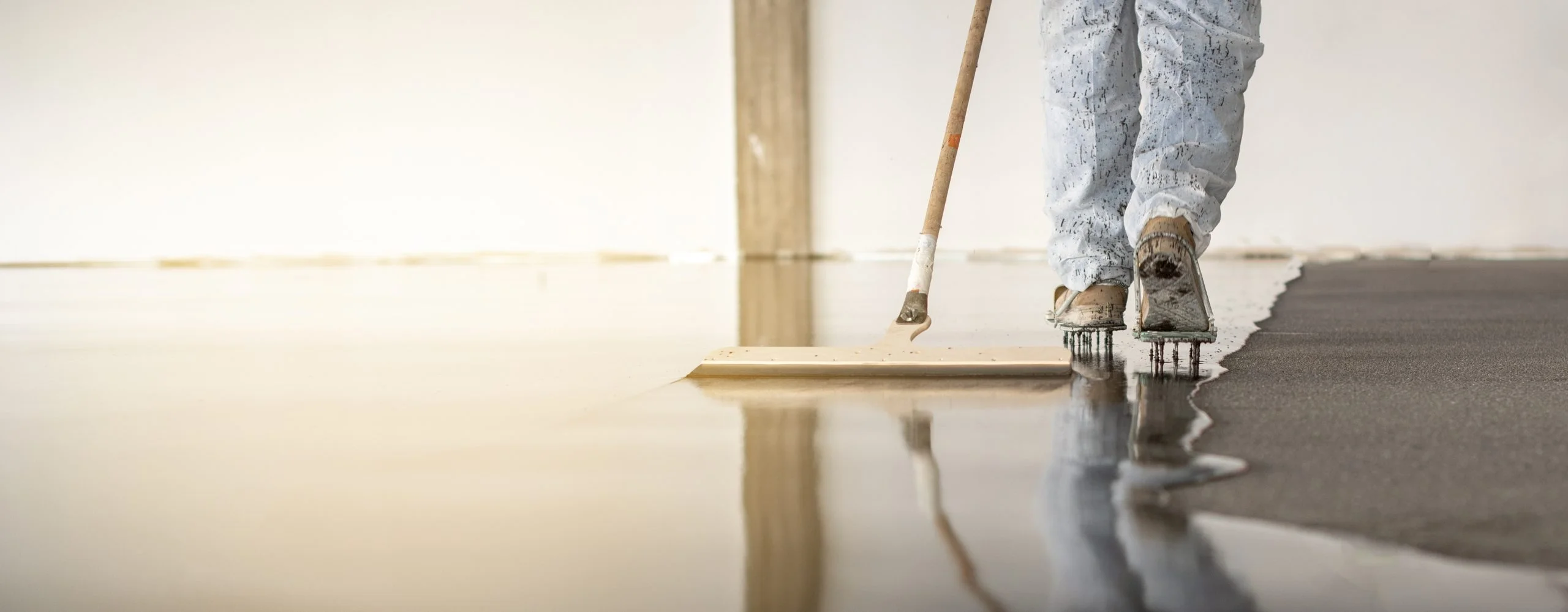 Worker working on the floor of an industrial building with special shoes to avoid damaging the floor.